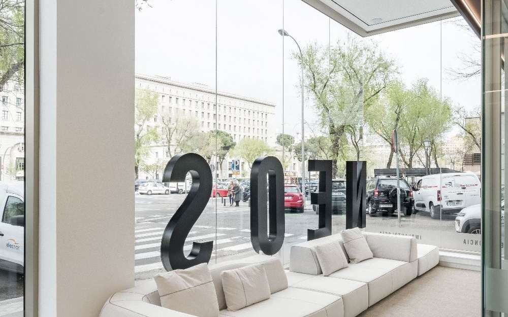 Sala de espera de clínica dental con sofá a medida y grandes ventanales
